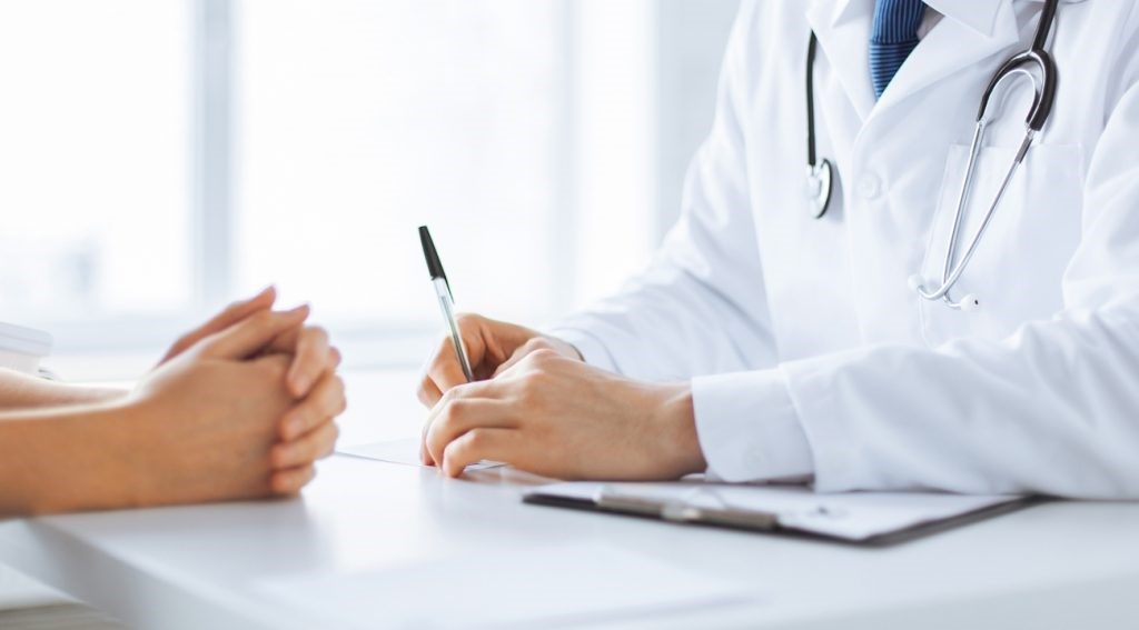 Foto do doutor escrevendo uma receita médica